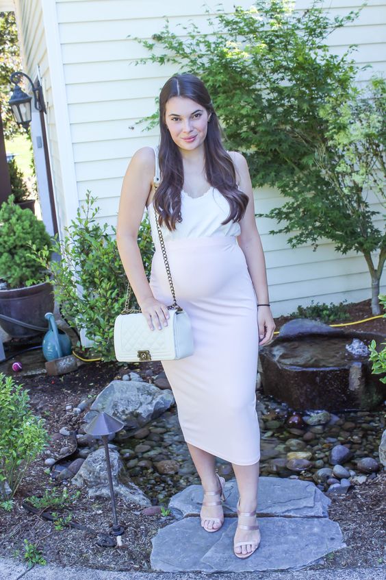 a casual summer wedding guest look with a blush high waisted midi, a white spaghetti strap top and a white bag