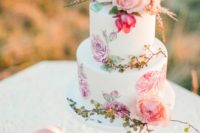 23 a chic handpainted wedding cake with blooms and greenery and flowers on top for a romantic wedding