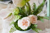 24 a beautiful summer wedding centerpiece with lots of greenery, blush anthuriums and peonies
