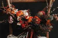 25 a textural and dramatic wedding bouquet with berries and rust blooms and ribbons for a fall wedding