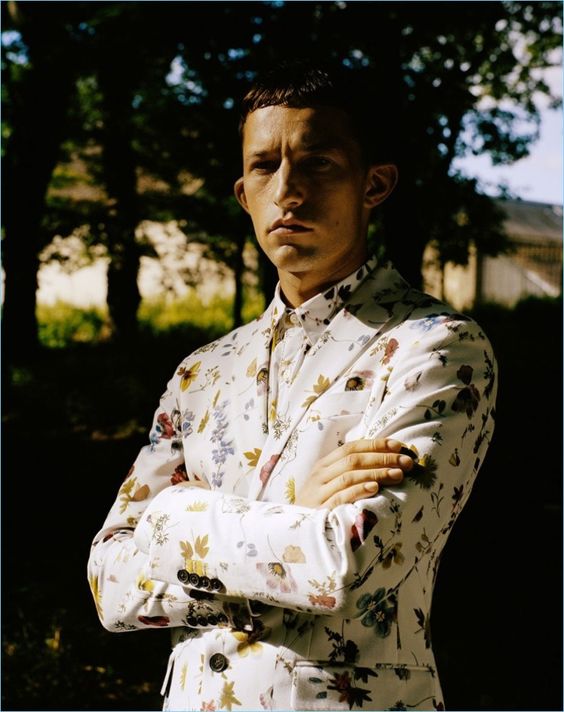 a white suit with a bright floral print and a matching shirt with no tie is a bold idea for a summer wedding