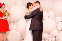 26 a white balloon wedding backdrop and lights hanging down make up a modern ceremony space