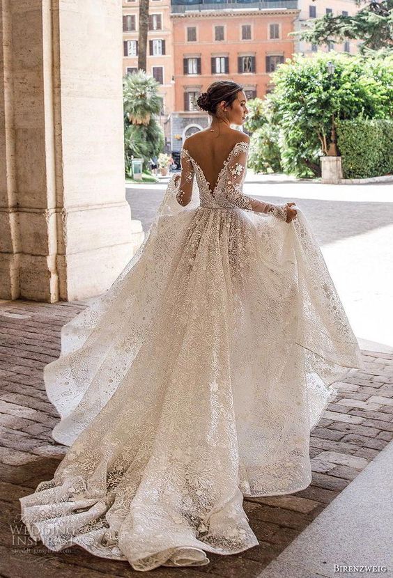 a floral lace ballgown with long sleeves, embellishments and a chapel train
