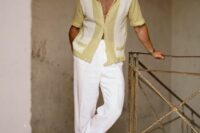 a catchy and chic beach wedding guest outfit with a printed yellow shirt, white trousers and neutral loafers