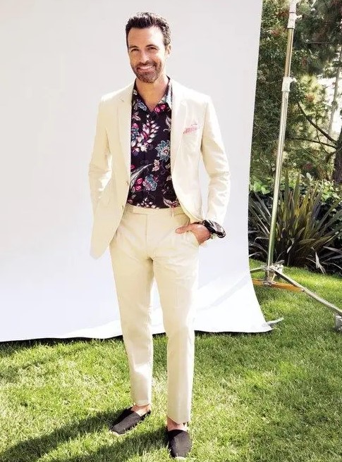 a creamy suit, black espadrilles and a moody floral shirt, which is great for a tropical wedding