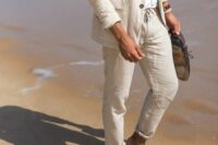a neutral linen pantsuit, a white shirt, brown shoes and sunglasses are a cool effortless look for a beach wedding