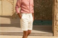 a simple yet elegant beach wedding guest look with a pink linen shirt, white shorts and grey loafers can be easily repeated