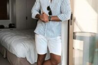 a stylish beach wedding guest look with a blue and white stripe shirt, white shorts, white sneakers is easy to repeat