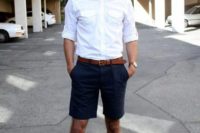a white shirt, navy shorts, a brown belt and brown moccasins plus sunglasses for a comfy look