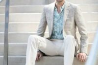 an elegant tropical wedding guest look with a printed grene shirt, creamy pants, a neutral textural blazer and brown loafers