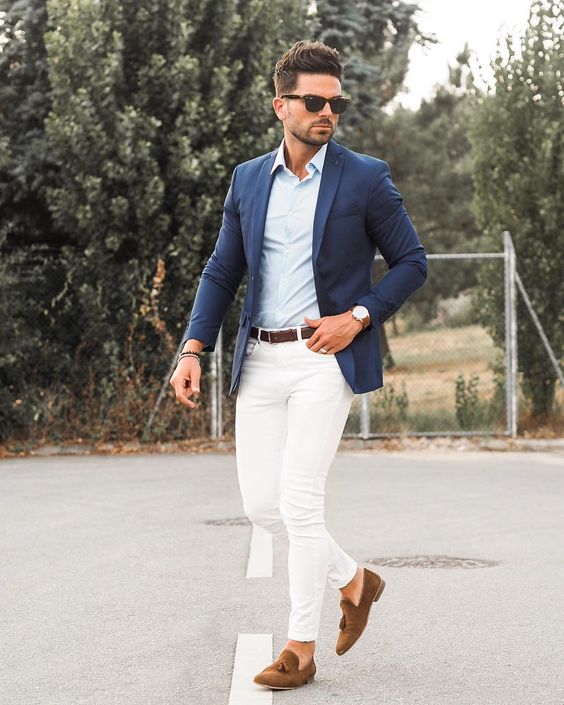 creamy jeans, a light blue shirt, a navy blazer, brown moccasins and sunglasses for a timeless beach look