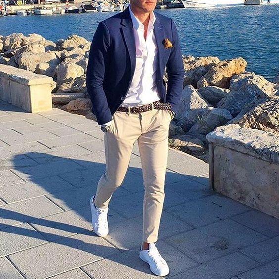 tan pants, a white shirt, a navy blazer and white sneakers that create a more modern look