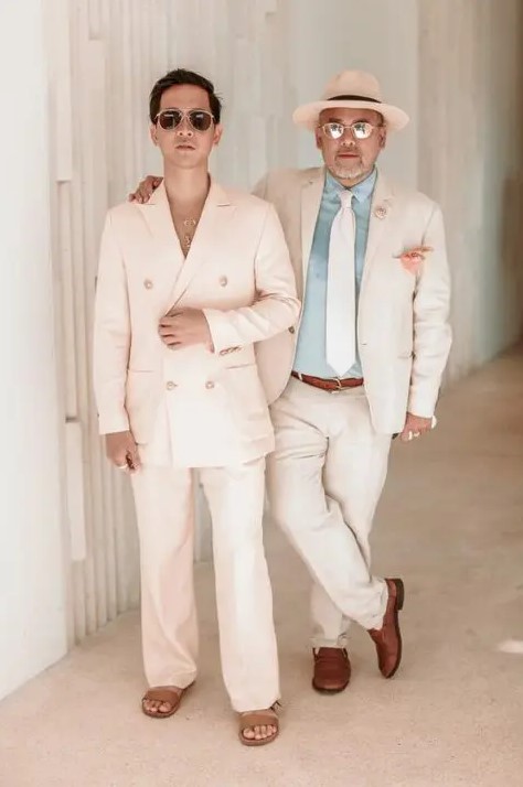 tropical wedding guest outfits, one with a creamy pantsuit and tan sandals, the second with a creamy suit, a blue shirt and creamy tie, a hat and brown loafers