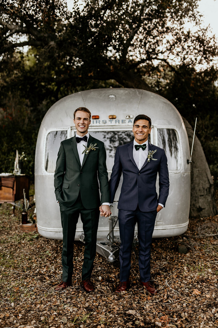 One groom was wearing a green, and the other a navy tuxedo with velvet bow ties