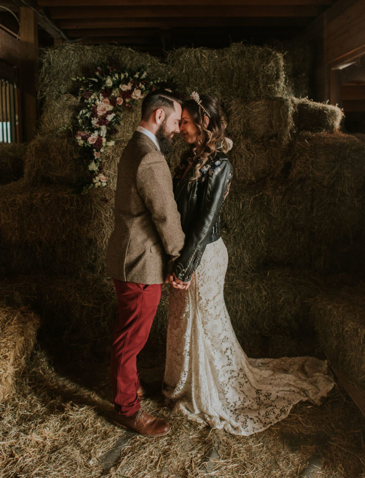 Flower embellished hay bales for a wedding backdrop is a very creative rustic idea