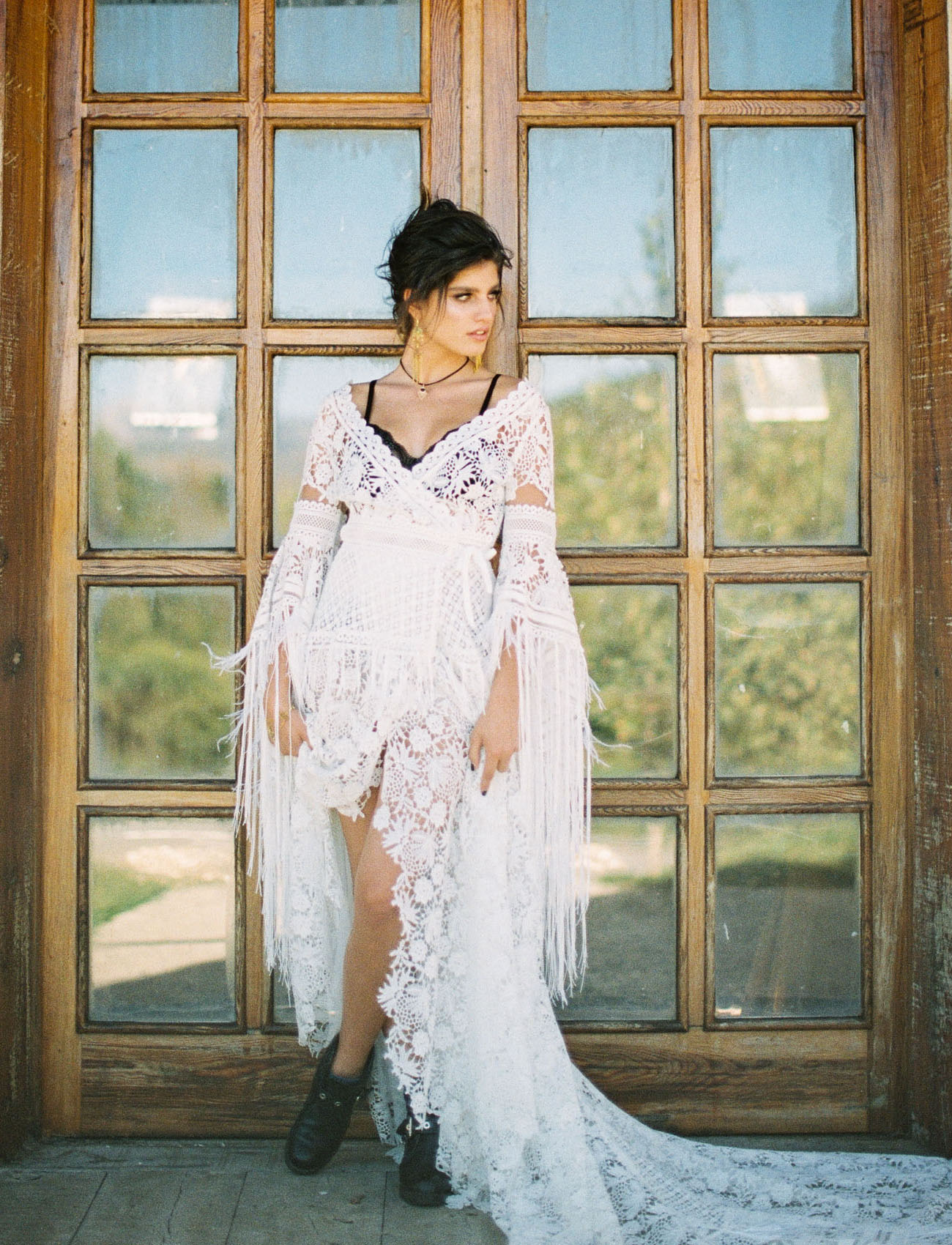 The bride was wearing a boho lace high low wedding dress with a train and black booties