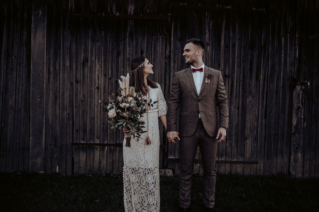 The groom was wearign a brown checked suit, a red bow tie and a white shirt
