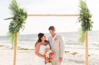 04 a bamboo wedding arch decorated with lush tropical greenery is amazing for a tropical beach wedding