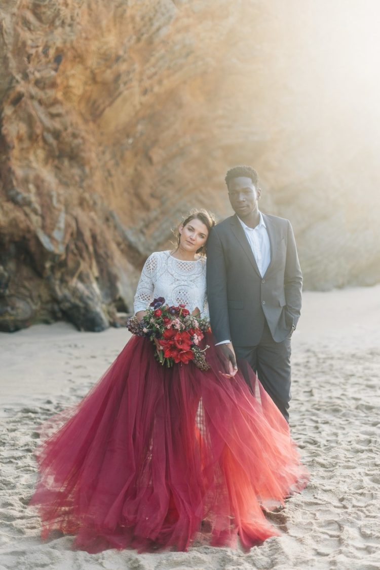 a bold color block bridal outfit with a white boho lace top with long sleeves and a burgundy tulle skirt