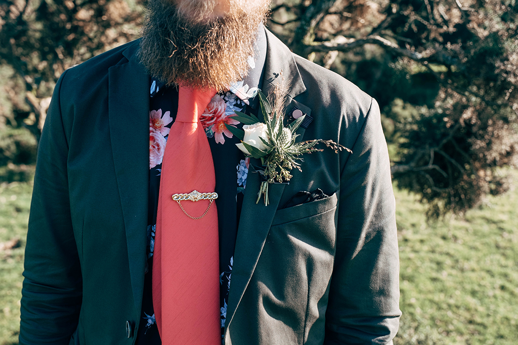 The groom was dressed as a badass, in a grey suit, a moody florla shirt and a hot red tie
