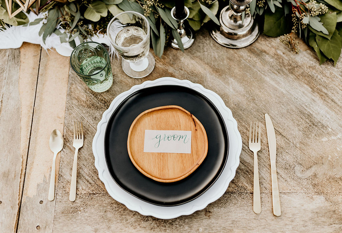 The place settings were done with vintage chargers, black plates and wooden ones on top