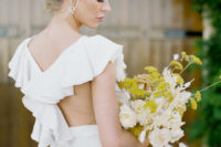08 The wedding dress featured a ruffled racerback, the bride was carrying a chic bouquet with yellow and creamy blooms and grasses