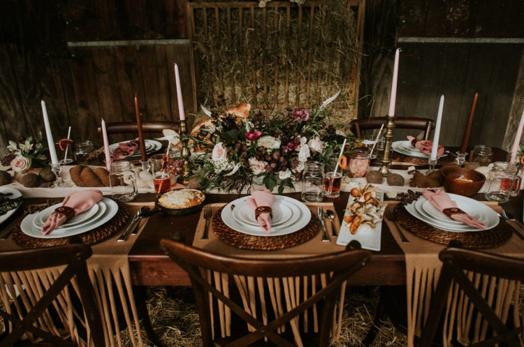The wedding tablescape was done with pink napkins, wicker chargers, fringe placemat, various candles and a lush floral centerpiece