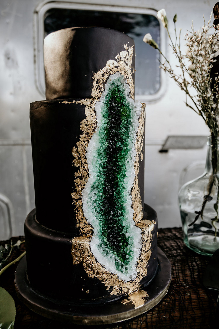Look at this masterpiece, a black wedding cake with emerald geode and a touch of gold leaf