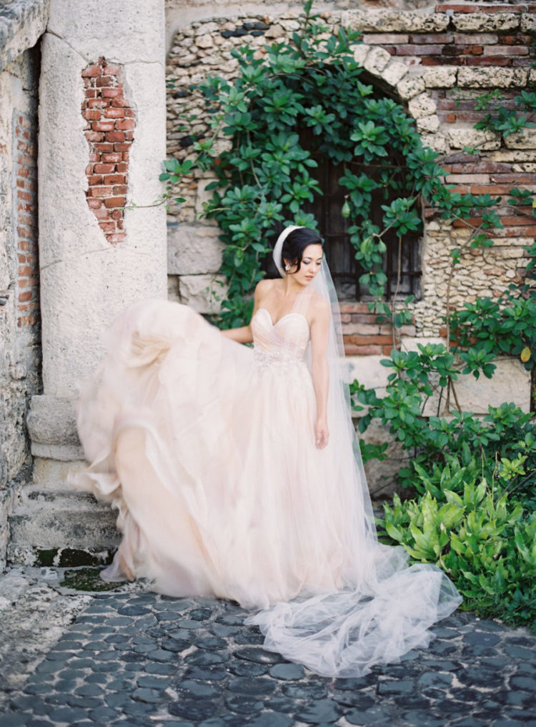 a blush strapless wedding ballgown with a sweetaheart neckline and a layered skirt with a train
