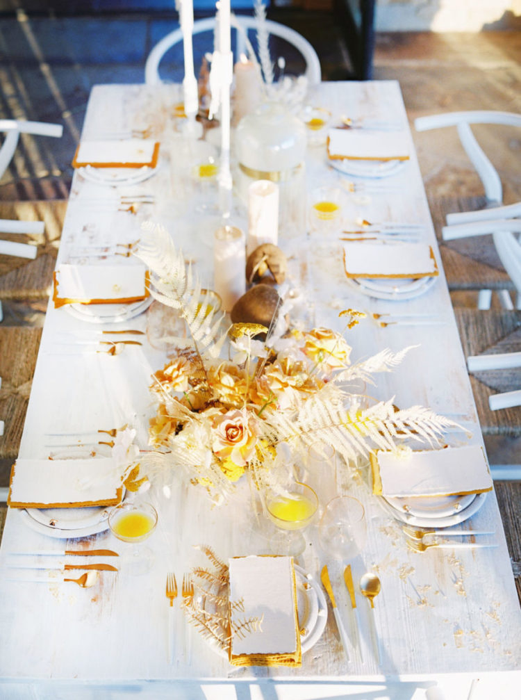 The reception table was also styled with gold and mustard touches, with a chic centerpiece and white candles