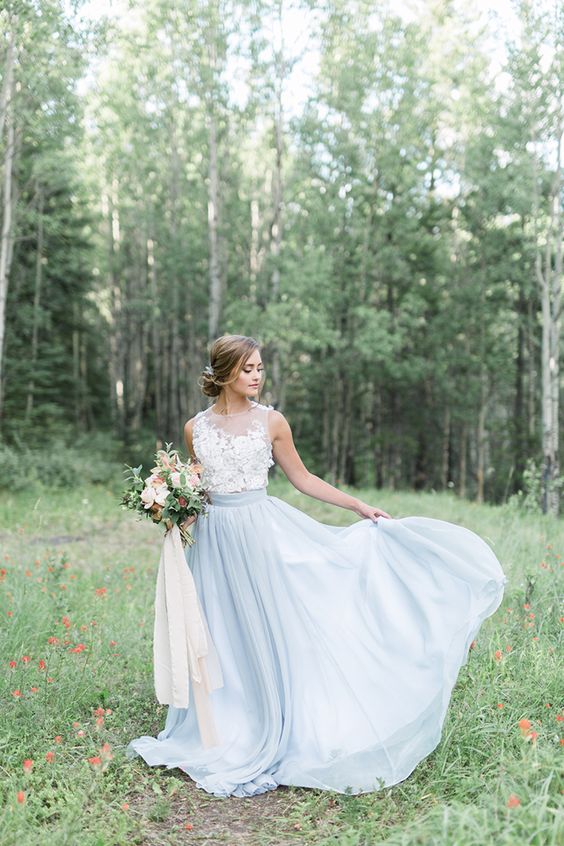 a tender bridal look with a white lace sleeveless top and a powder blue skirt with a train