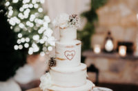 13 The wedding cake was naked and decorated with pinecones, white roses and baby’s breath