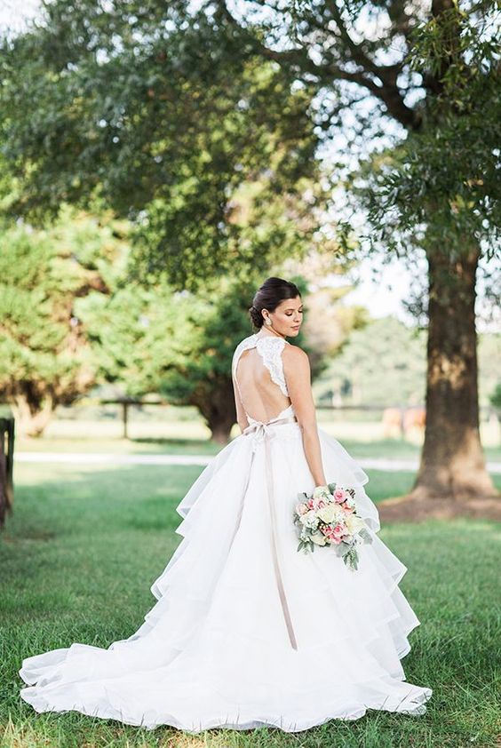 a chic wedding ballgown with a high neckline, a lace bodice with no sleeves and a cutout back