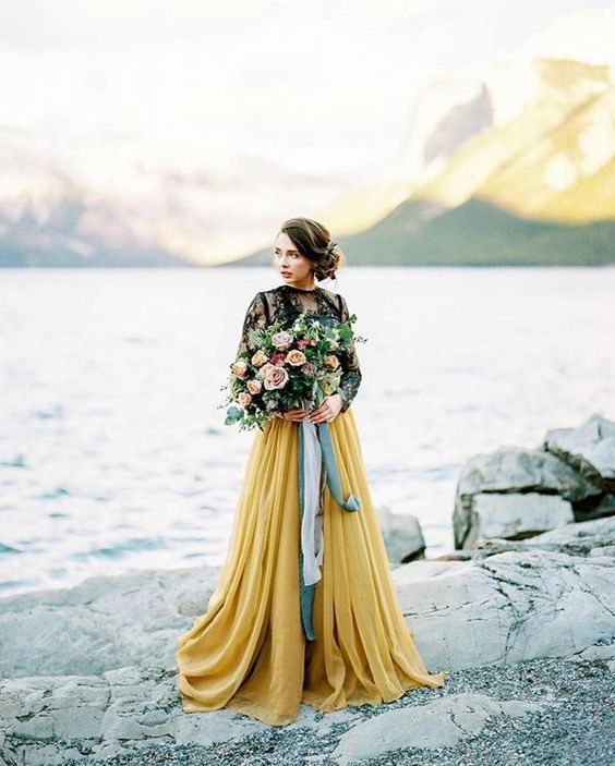 a daring bridal separate with a black lace top with long sleeves and a sunny yellow maxi skirt with pleating