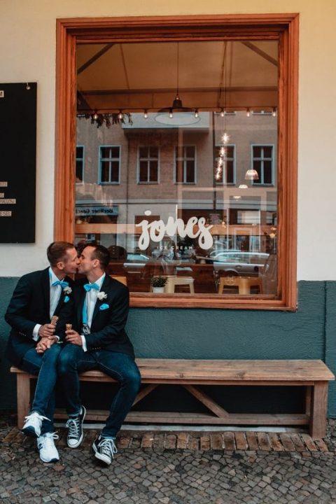 grooms wearing blazers, jeans, blue bow ties and different sneakers for a more unified look