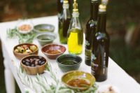 14 a small olive oil tastign bar with various kinds of oil and olives, nuts and herbs