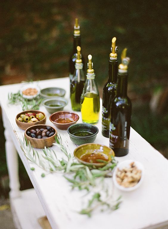 a small olive oil tastign bar with various kinds of oil and olives, nuts and herbs