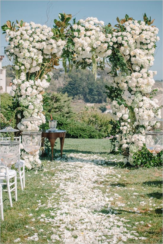 a gorgeous and super lush wedding arch with neutral roses and magnolia leaves for a summer wedding