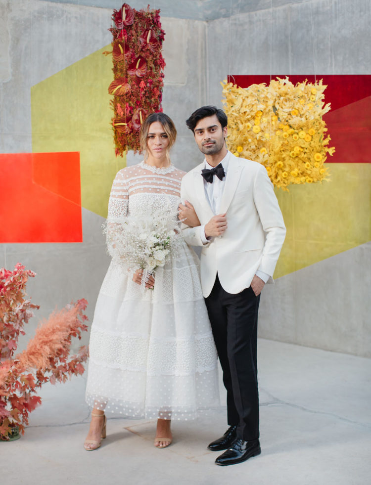 a color block wedding backdrop with burgundy, yellow and red figures and floral installations