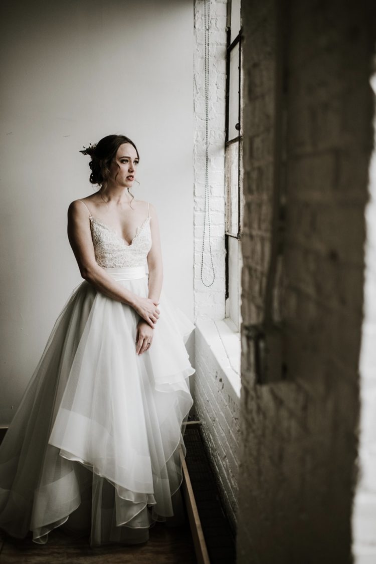 a romantic wedding ballgown with a lace bodice and spaghetti straps and a layered high low skirt