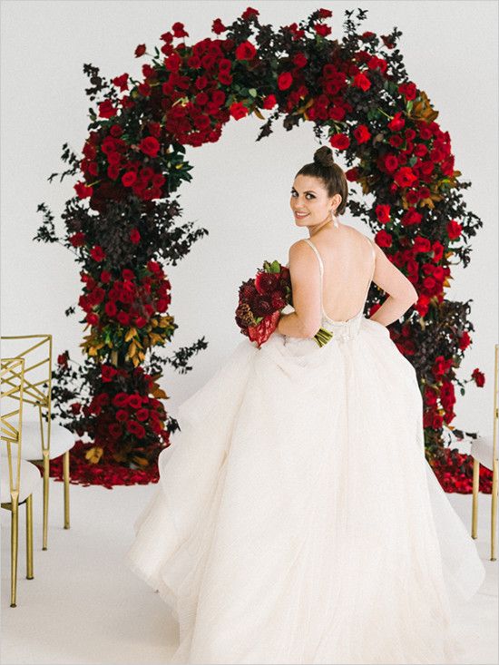 a lush red rose wedding arch with much greenery is a luxurious idea that always works