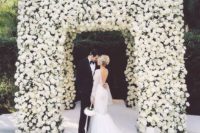 22 a modern and luxurious wedding chuppah fully covered with white roses is a stunning statement