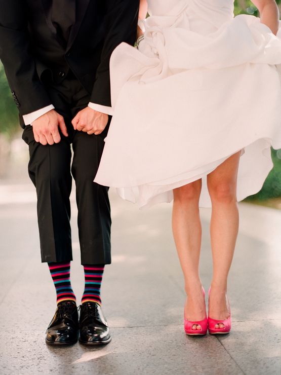the bride showing off her bright heels and the groom showing off his funny colorful socks