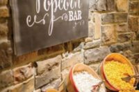 23 a large popcorn bar with wooden baskets and a chalkboard sign with letters