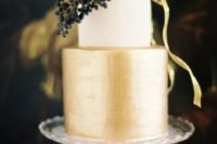 26 a color block wedding cake with a white and gold tier plus some berries on top for timeless elegance