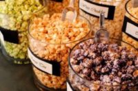 26 a flavored popcorn wedding bar with popcorn in glass jars and labels on them to mark the types