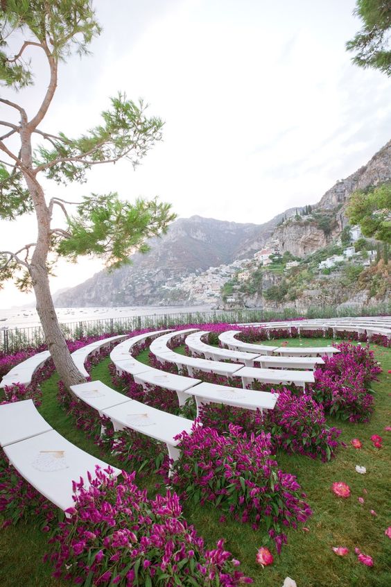 a wedding ceremony space done with purple blooms even under the benches is a gorgeous modern idea