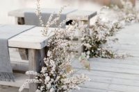 29 neutral blooms and pale foliage by the benches create a frozen winter wedding aisle