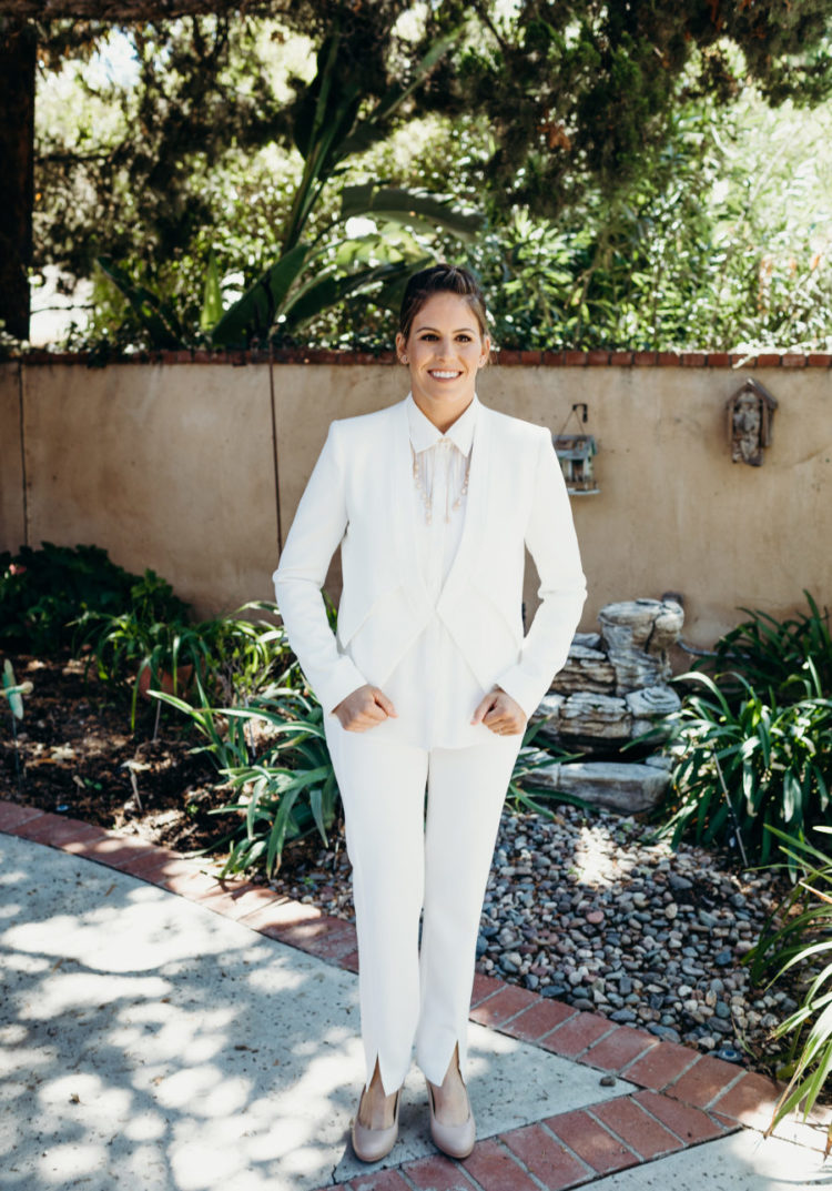 One bride chose a braided updo, a white suit with a necklace and nude shoes