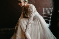 02 The bride was wearing a blush and ivory lace wedding dress with a deep V-neckline and long sleeves and a messy updo with blooms